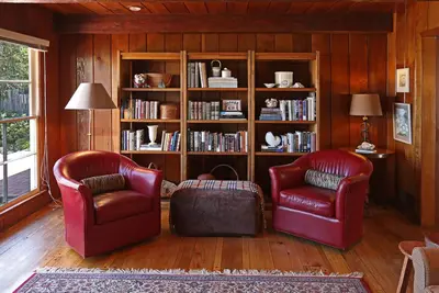 a living room with two chairs and a book shelf at Rincon Retreat by Paradise Retreats in Carpinteria