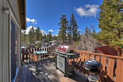 a balcony with a grill and a table and chairs at Modern Lake Cabin for Family, Friends and Pets! in Big Bear Lake
