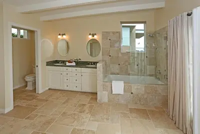 a bathroom with a tub and a sink and mirror at Seacliff Beach House by Paradise Retreats in Ventura