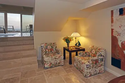 a living room with two chairs and a table with a lamp at Seacliff Beach House by Paradise Retreats in Ventura