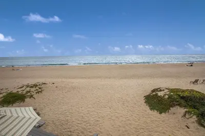 a sandy beach with an ocean and an umbrella at Seahorse Retreat by Paradise Retreats in Carpinteria