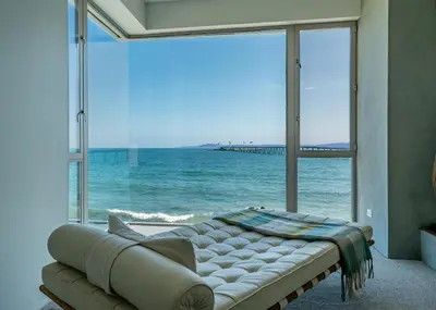 a room with a couch in front of a large window at Seascape by Paradise Retreats in Carpinteria
