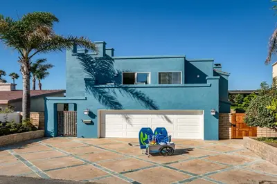 a blue house with a lawn chair in front of it at Summer Sunset by Paradise Retreats in Ventura