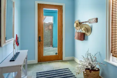 a hallway with a wooden door and a window at Summer Sunset by Paradise Retreats in Ventura