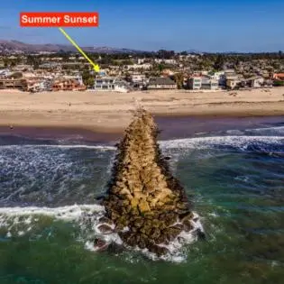 a small rock in the water next to a beach at Summer Sunset by Paradise Retreats in Ventura