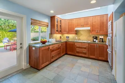 a large kitchen with wooden cabinets and a table at Summer Sunset by Paradise Retreats in Ventura