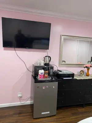 a room with a television on a pink wall at Just The Two Of Us -Romantic Pool View And Private Entry Sleeps 2 Near CSUN CSUN in North Hills