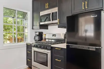 a kitchen with stainless steel appliances and black cabinets at Newly Renovated Villa 6 Beds Fenced-in Backyard in Big Bear Lake