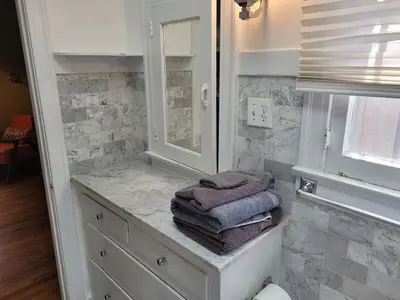 a bathroom with towels on a counter and a mirror at Hollywood Bungalow One with Patio! in Los Angeles