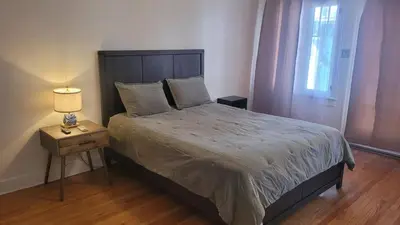 a bedroom with a bed and a table with a lamp at Amazing Hollywood Bungalow Three! in Los Angeles