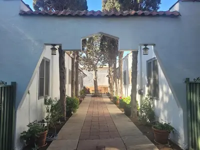 a walkway leading to a blue house with trees at Amazing Hollywood Bungalow Three! in Los Angeles