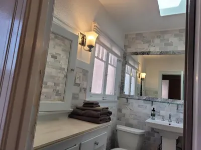 a bathroom with a sink and a toilet and a mirror at Beautiful Bungalow Five in Hollywood! in Los Angeles