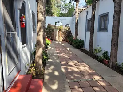a sidewalk with a red bench next to a building at Beautiful Bungalow Five in Hollywood! in Los Angeles