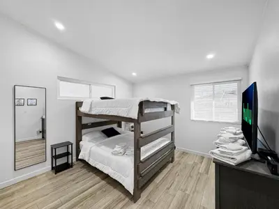 a bedroom with a bunk bed and a flat screen tv at Modern Home for Large Families by Disney & Knotts in Anaheim