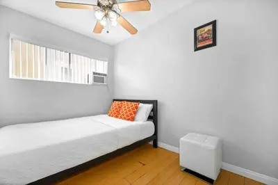 a white room with a ceiling fan and a bed at Elegant Beachside 2 Bed 2 Bath in Long Beach