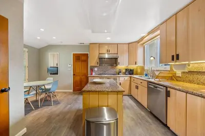 a large kitchen with wooden cabinets and a table at Beverly Hills 6BR Haven w Pool Hot Tub in Los Angeles