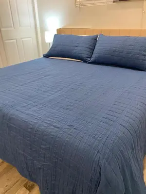 a blue bed with a blue comforter on it at HubCityJewel in Compton
