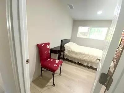 a room with a red chair and a bed at In a quiet neighborhood near the Main Street-Room C in Rowland Heights