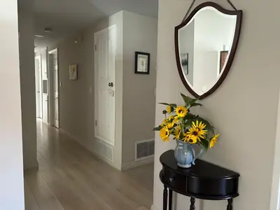 a vase of flowers on a table with a mirror at In a quiet neighborhood near the Main Street-Room C in Rowland Heights