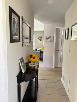 a hallway with a table with a vase of flowers on it at In a quiet neighborhood near the Main Street-Room C in Rowland Heights