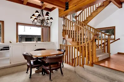 a dining room with a wooden table and stairs at Bear Lake Lodge #2547 in Big Bear Lake