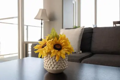 a vase filled with yellow flowers sitting on a table at Stylish 3BR High-Rise with Pool, Hot Tub & Rooftop Views in Los Angeles