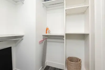 a walk in closet with white cabinets and a fireplace at Stylish 3BR High-Rise with Pool, Hot Tub & Rooftop Views in Los Angeles