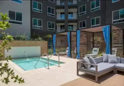 a patio with a couch and a pool in front of a building at Cozy 2 Bedroom Apartment Near Disneyland and Anaheim Convention Center in Orange