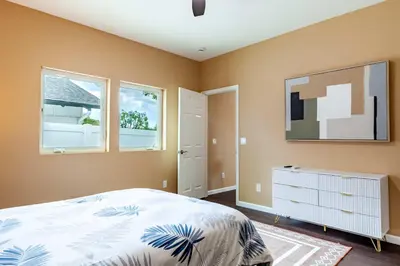a bedroom with a bed and a tv and two windows at Cozy 2BR Home Mountain Views Pet Friendly in Thousand Oaks
