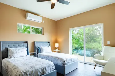 a bedroom with two beds and a chair and a window at Cozy 2BR Home Mountain Views Pet Friendly in Thousand Oaks