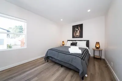 a white bedroom with a bed and a window at Gated Private Home next to Universal Studios in Van Nuys County Court Heliport