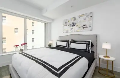 a white bedroom with a large bed and a window at Snazzy 3 Bedroom High Rise with Pool, Hot Tub and Rooftop Deck in Los Angeles