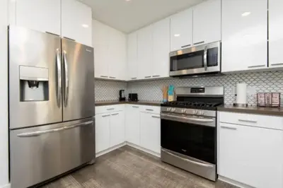 a kitchen with stainless steel appliances and white cabinets at Snazzy 3 Bedroom High Rise with Pool, Hot Tub and Rooftop Deck in Los Angeles