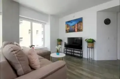 a living room with a couch and a television at Beautiful 3 Bedroom High Rise with Pool, Hot Tub and Rooftop Views in Los Angeles