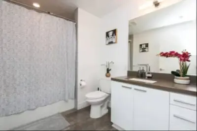 a white bathroom with a toilet and a shower at Beautiful 3 Bedroom High Rise with Pool, Hot Tub and Rooftop Views in Los Angeles