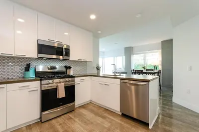 a kitchen with white cabinets and a stove top oven at Beautiful 3 Bedroom High Rise with Pool, Hot Tub and Rooftop Views in Los Angeles