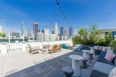 a rooftop patio with furniture and a view of the city at Beautiful 3 Bedroom High Rise with Pool, Hot Tub and Rooftop Views in Los Angeles