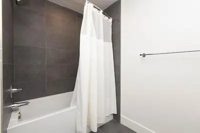 a bathroom with a white shower curtain and a tub at Walk to Santa Monica Beach, Pier, Boardwalk and Venice in Los Angeles