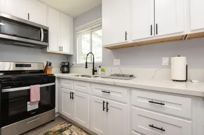 a kitchen with white cabinets and a sink and a stove at Spacious 3 Bedroom 2 Bathroom Apartment with Free Onsite Parking in Los Angeles