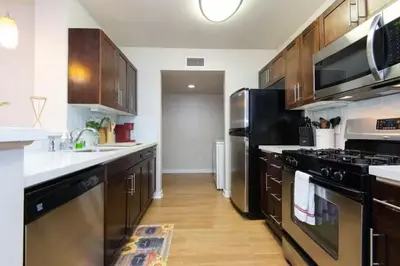 a kitchen with black appliances and wooden cabinets at Downtown Los Angeles Gem 2 in Los Angeles