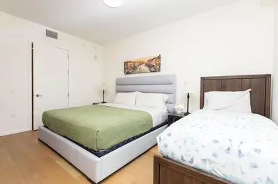 a white bedroom with two beds and a window at Cozy 3BR High Rise with Pool with great views in Los Angeles