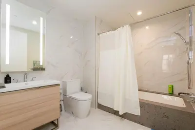 a bathroom with a toilet and a sink and a shower at Cozy 3BR High Rise with Pool with great views in Los Angeles