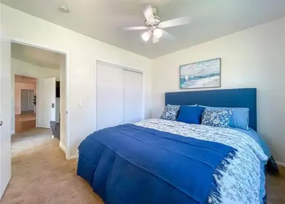 a bedroom with a blue bed with a ceiling fan at Hillside-This is a House with 5 master suite in Riverside