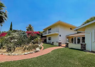 a large house with a yard with grass and flowers at Hillside-This is a House with 5 master suite in Riverside