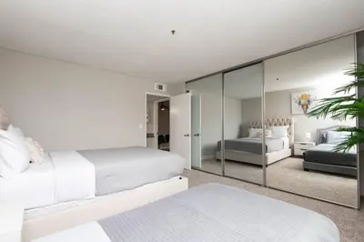 a bedroom with two beds and a mirror at Snazzy 2 Bedroom Pad with Rooftop Pool and Hollywood Sign View in Los Angeles
