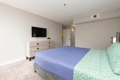 a bedroom with a bed and a tv on a dresser at Snazzy 2 Bedroom Pad with Rooftop Pool and Hollywood Sign View in Los Angeles