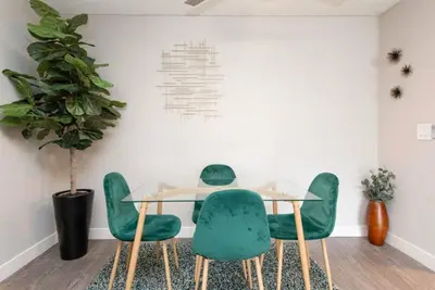 a dining room with a table and green chairs at Snazzy 2 Bedroom Pad with Rooftop Pool and Hollywood Sign View in Los Angeles