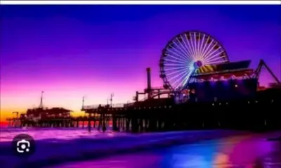 a ferris wheel at a carnival at sunset at Hosp Walk to Santa Monica Beach Pier in Los Angeles