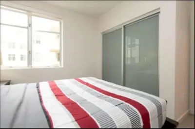 a bedroom with a bed with a red and white striped blanket at Hosp Walk to Santa Monica Beach Pier in Los Angeles