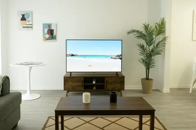 a living room with a flat screen tv on a table at Spacious 2BR Townhouse - 3 Queens - Sleeps 8 in Redondo Beach